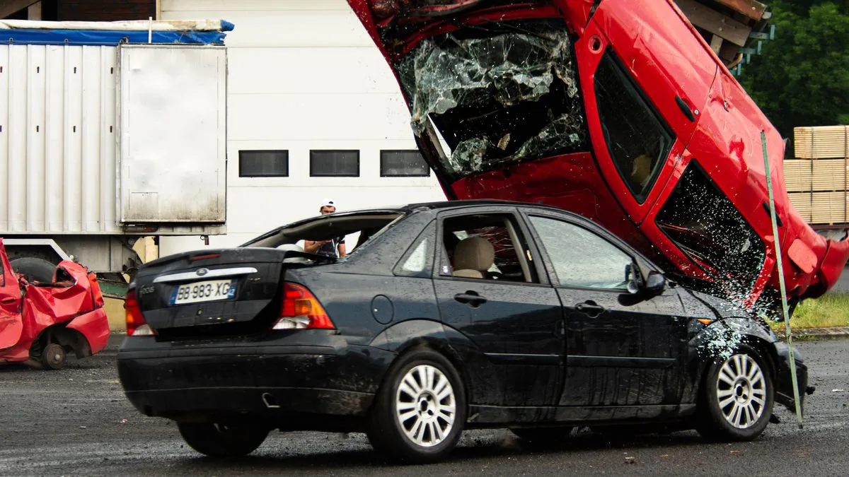 Wrecked car resting on top of a crushed sedan after a collision